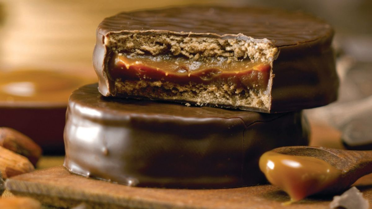 Alfajor Havanna de chocolate relleno de dulce de leche, partido a la mitad, mostrando su interior cremoso