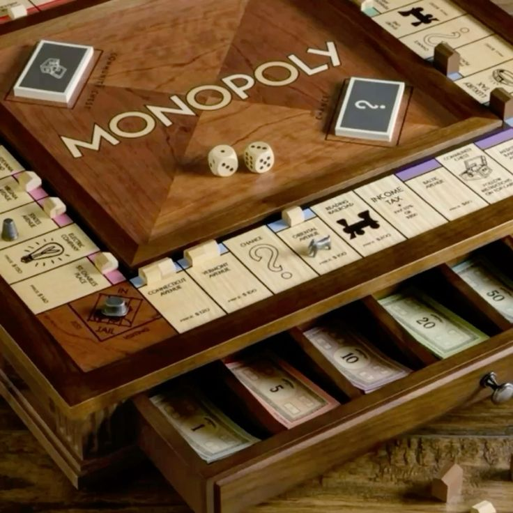 Luxury wooden Monopoly board game with dice, property cards, and organized money drawers.