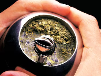 Mate argentino con yerba de hojas y palos, listo para tomar con bombilla de metal
