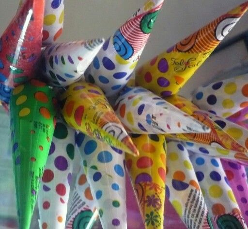 Paragüitas de chocolate envueltos en papel de colores con lunares, exhibidos colgados como en un kiosco argentino