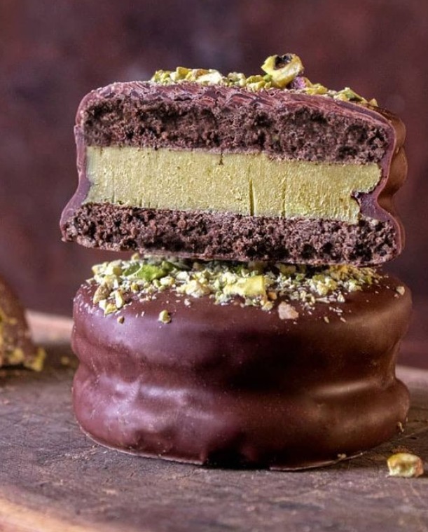 Chocolate alfajor filled with pistachio cream and topped with crushed pistachios.
